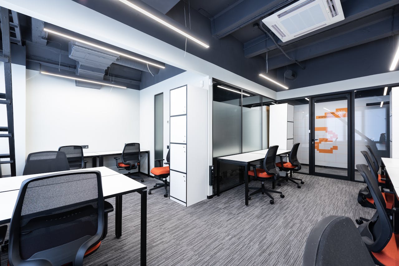 Spacious and modern office interior with sleek furniture and bright lighting.